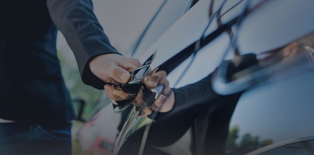 A limo company driver opens the door of a limo purchased with a small business loan